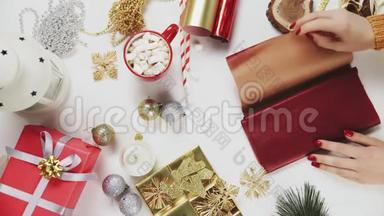 准备<strong>红纸</strong>包装圣诞礼物的女人。 垂直屏幕定位视频9：16